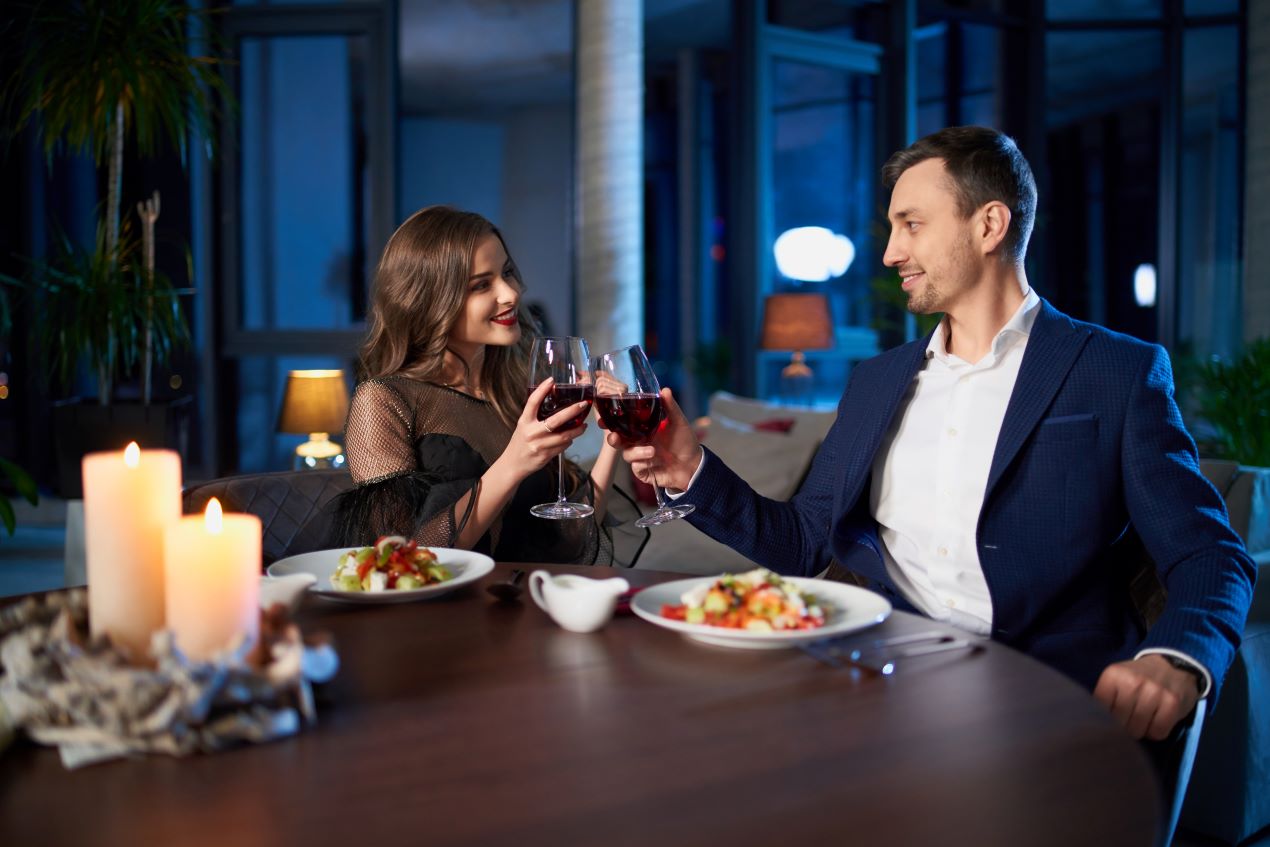 Ein Paar genießt ein romantisches Abendessen mit Kerzenlicht und Rotwein – ein exklusives Erlebnis mit Escort Düsseldorf.